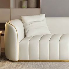 a white couch sitting next to a table on top of a carpeted room floor