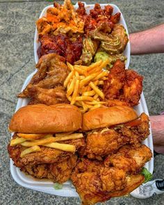 a tray filled with fried chicken, french fries and other foods on top of it