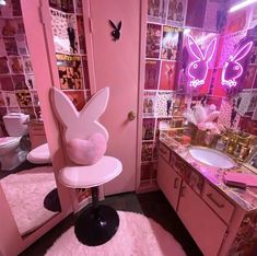 a bathroom decorated in pink and white with bunny ears on the back of the chair