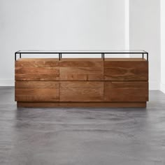 a large wooden cabinet sitting on top of a floor next to a white wall in an empty room