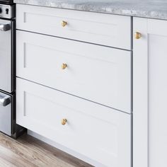 a white kitchen with marble counter tops and stainless steel appliance in the center