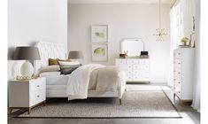 a bedroom with white furniture and gold accents on the walls, carpeted flooring