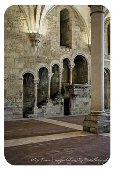 the inside of an old building with columns and arches