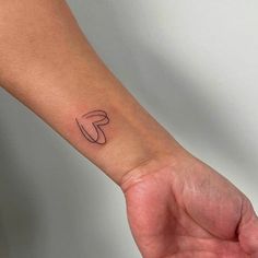 a person's arm with a small tattoo on the left side of their wrist