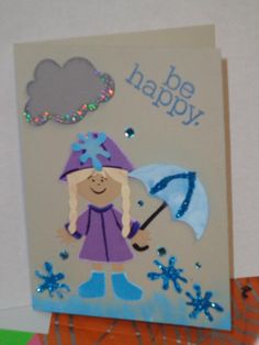 a card with a girl holding an umbrella and the words be happy written on it