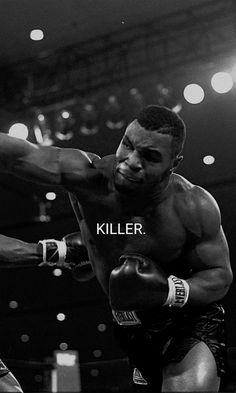 a black and white photo of two men boxing