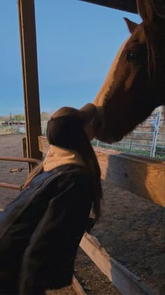 a horse sticking its head over the fence