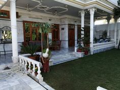 a house with white pillars and green grass