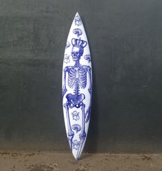 a blue and white surfboard with a skeleton on it