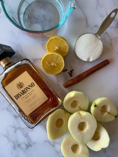 the ingredients to make an apple cider are displayed on a marble counter top, including sliced apples and cinnamon sticks