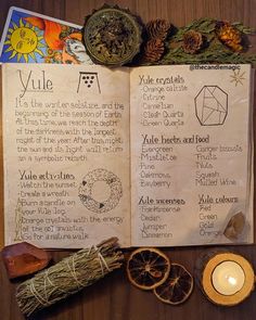 an open book sitting on top of a wooden table next to candles and other items