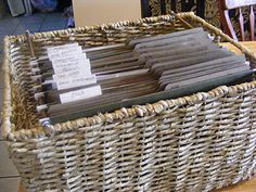 a wicker basket filled with files on top of a wooden table