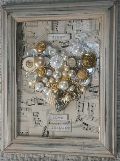 a heart made out of buttons in a frame with sheet music notes on the wall