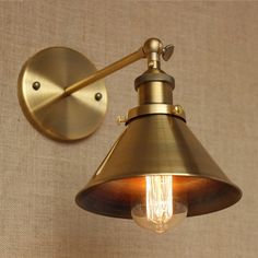 an old fashioned brass wall light with a bulb on the side and one light attached to it