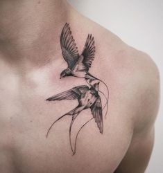 two birds flying next to each other in the air on a man's chest