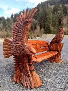 a wooden bench with an owl carving on it's back and another bird carved out of wood