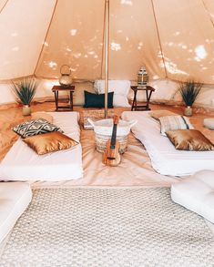 the inside of a tent with several pillows and an umbrella on it's side