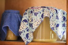 two blue towels on top of a wooden shelf