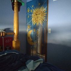 a bedroom with blue walls and a sun painted on the door