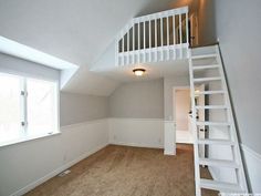 an empty room with stairs leading up to the second floor and another window in the corner