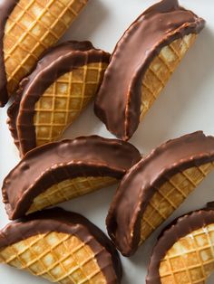 chocolate covered waffles are arranged on a white plate and ready to be eaten