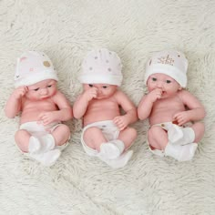 three baby dolls sitting next to each other