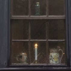 a candle is lit in front of a window