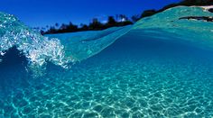 an underwater view of the ocean with clear blue water