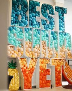 the word fresh is spelled out with balloons and pineapples in front of it