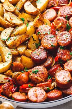 a pan full of cooked sausages and potatoes with parsley on the side, ready to be eaten