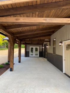 an empty covered patio with doors and windows on the side of the building is seen in this image