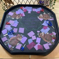 a black tray topped with lots of cut up pieces of paper and scissors on top of it