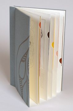 an open book with four different pages on the front and one is in grey, white, and orange