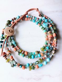 Really stunning double layer necklace. Classic Sundance style..beautiful color. Upper strand of necklace is approx 22" and the lower strand 24" in length, and extendable another 3". A variety of southwestern tones in different shapes and textures. Mixed gemstone necklace including African Turquoise, Laramar, Opal, BumbleBee Jasper, Turquoise and orange Howlite, Jade, colorful Jaspers, Mookaite, Mother of Pearl disks, and more. Mix in Bohemian Glass Crow beads, bone beads, several colorful Java b Double Strand Beaded Necklace, Sundance Style, Necklace African, Bumblebee Jasper, Double Layer Necklace, Hello Weekend, African Turquoise, Layer Necklace, Bone Beads