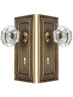 an antique brass door handle with crystal knobs and two glass knobs on each side