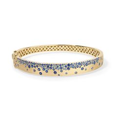 Discover the brilliance of our Scattered Gemstone Bangle and let your style shine. Whether you're dressing up for a special occasion or adding a touch of sophistication to your everyday look, this bangle is the perfect accessory to express your unique style and radiant personality. Available in 14K Yellow Gold Fits a size 17cm wrist Blue Sapphire weight = 2.61 carats Elegant Blue Diamond Bangle, Sparkling Fine Jewelry Bangle Bracelet, Sapphire Bangle, Gemstone Bangle, Diamond Cocktail Rings, Sapphire Bracelet, Band Bracelet, Diamond Shop, Bracelet Collection