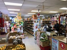 a grocery store filled with lots of food and people standing in front of the counter