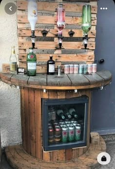 an outdoor bar made out of pallets with bottles and cans on the top shelf