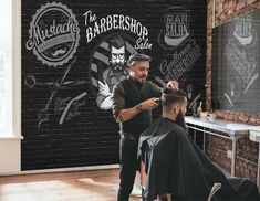 a man getting his hair cut in front of a barbershop sign and brick wall