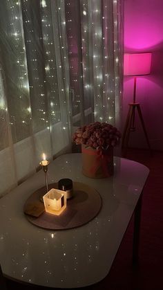 a table with a lit candle on it in front of a window and some curtains