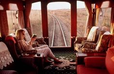 two women are sitting on a train looking out the window