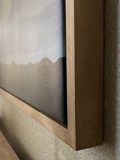 a painting hanging on the wall next to a wooden shelf