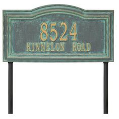 a green and gold plaque with the name of an address