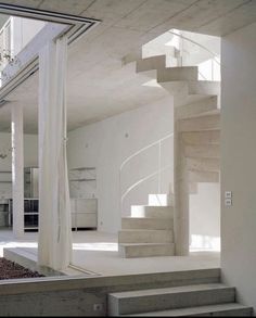 the interior of a house with white walls and concrete steps leading up to an open floor plan