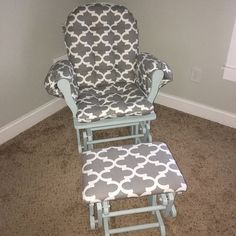 a baby's rocking chair and foot stool in the corner of a room with carpet