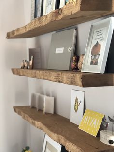 three wooden shelves with pictures and books on them