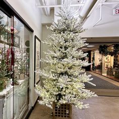 a white christmas tree sitting in the middle of a store