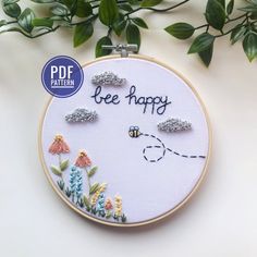 the embroidery pattern is being displayed in front of a plant