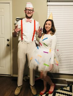 a man and woman dressed up as pinatas for a costume party, standing in front of a door