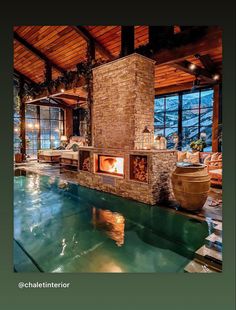 the indoor fireplace is built into the side of the swimming pool